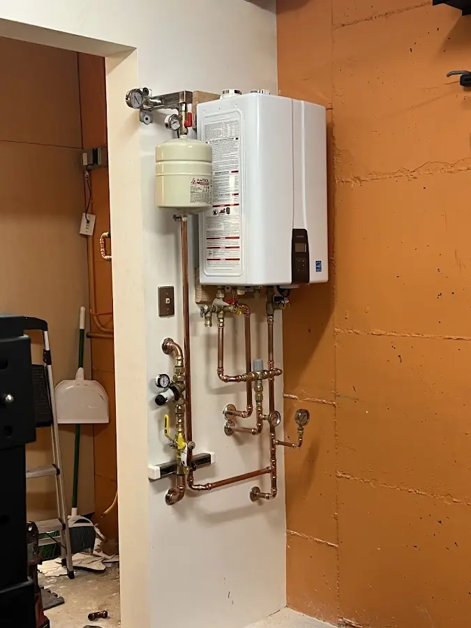 Plumbing technician inspecting water heater connections in Rossville